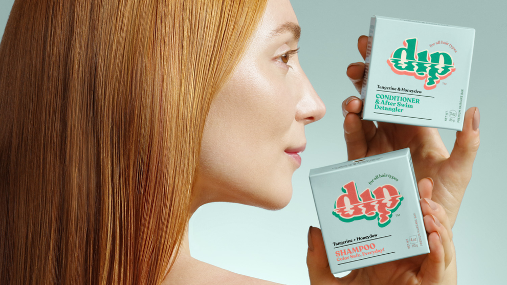 Woman holding shampoo and conditioner hair care products